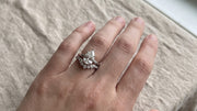Pear shaped lab grown diamond engagement ring worn with a curved band